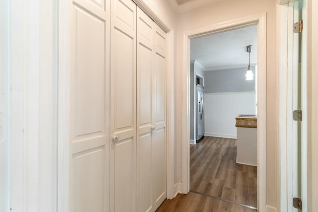 corridor with dark wood-type flooring and crown molding