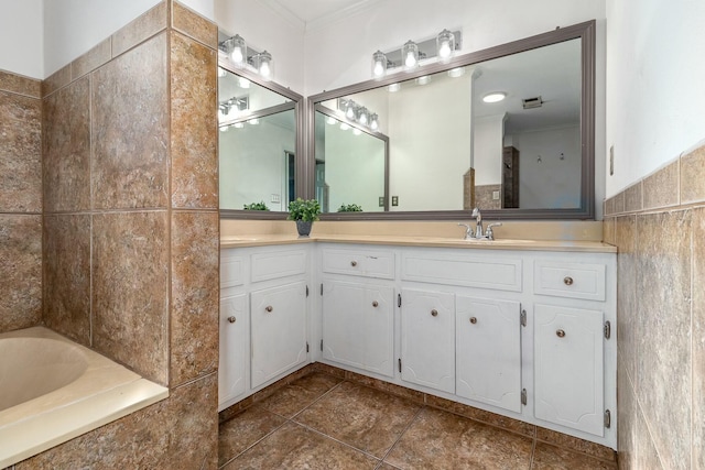 bathroom featuring tiled bath, vanity, and ornamental molding