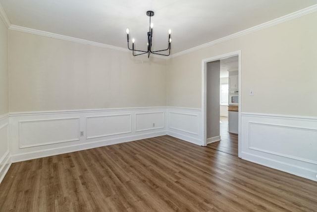 unfurnished dining area featuring dark hardwood / wood-style floors, a chandelier, and ornamental molding