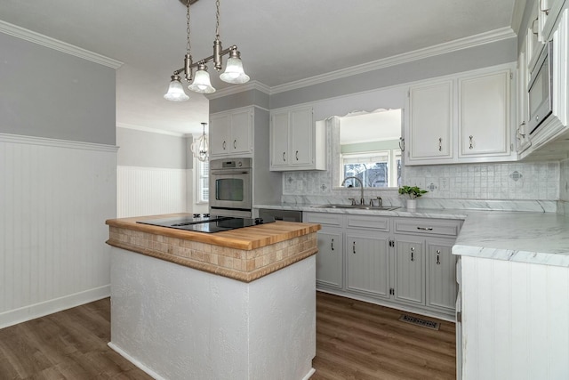 kitchen with decorative light fixtures, white cabinets, and appliances with stainless steel finishes