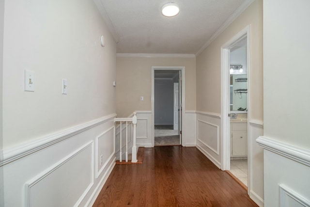 hall featuring hardwood / wood-style floors, crown molding, and a textured ceiling