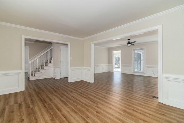 empty room featuring ceiling fan, wood-type flooring, and crown molding