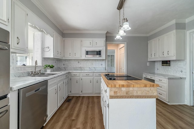 kitchen with a kitchen island, white cabinetry, stainless steel appliances, backsplash, and hanging light fixtures