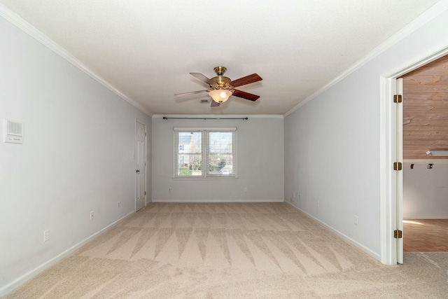 empty room with ceiling fan, ornamental molding, and light carpet