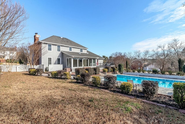 back of property featuring a fenced in pool and a yard