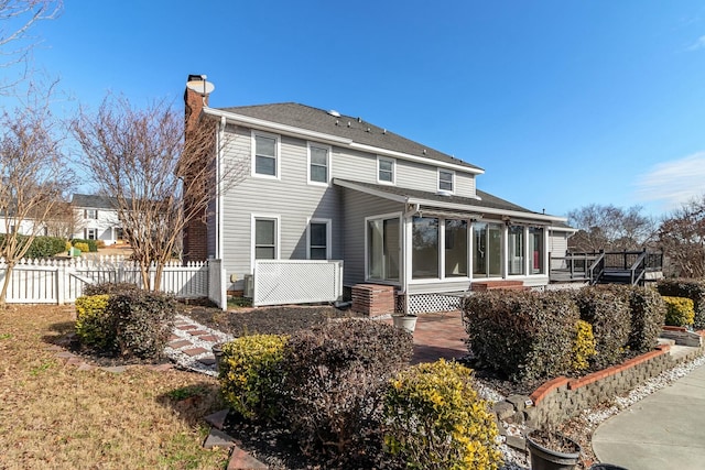 rear view of house featuring a sunroom