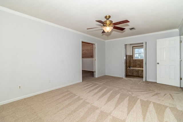 unfurnished bedroom featuring ceiling fan, a walk in closet, light colored carpet, and connected bathroom