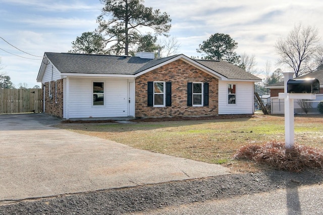 single story home featuring brick siding, a shingled roof, fence, a chimney, and a front yard