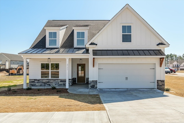 modern farmhouse featuring driveway, a standing seam roof, covered porch, and board and batten siding