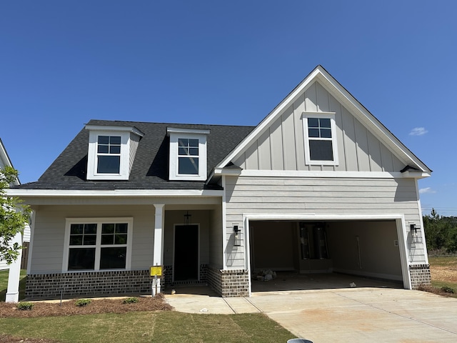 craftsman-style house with a porch, concrete driveway, a shingled roof, and board and batten siding