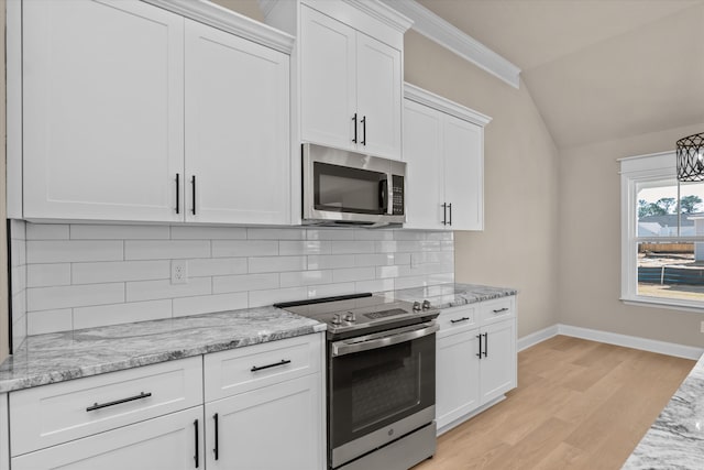 kitchen featuring stainless steel appliances, vaulted ceiling, light wood-style flooring, white cabinetry, and baseboards