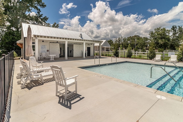 community pool with a patio area and fence