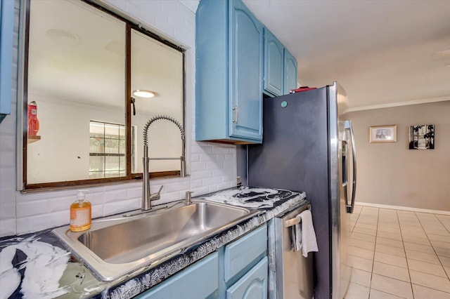 kitchen with ornamental molding, blue cabinetry, tasteful backsplash, a sink, and light tile patterned floors