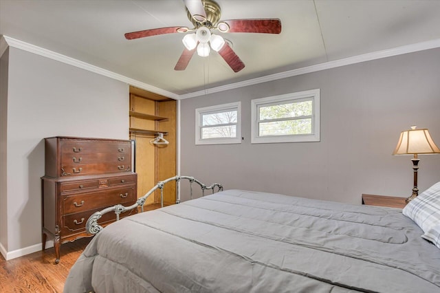 bedroom with baseboards, wood finished floors, ornamental molding, and a ceiling fan