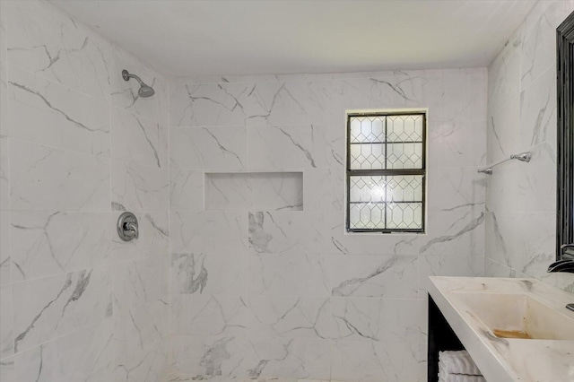 full bath with tiled shower and vanity