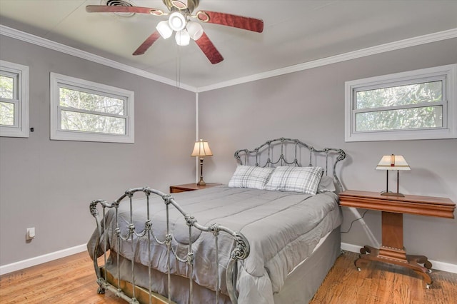 bedroom featuring ornamental molding, wood finished floors, and multiple windows