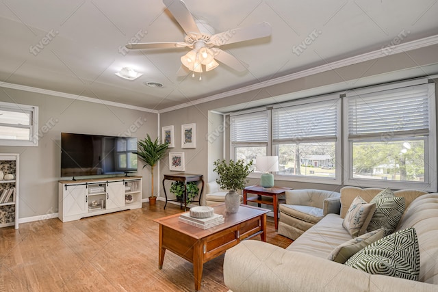 living area with baseboards, ornamental molding, and a ceiling fan