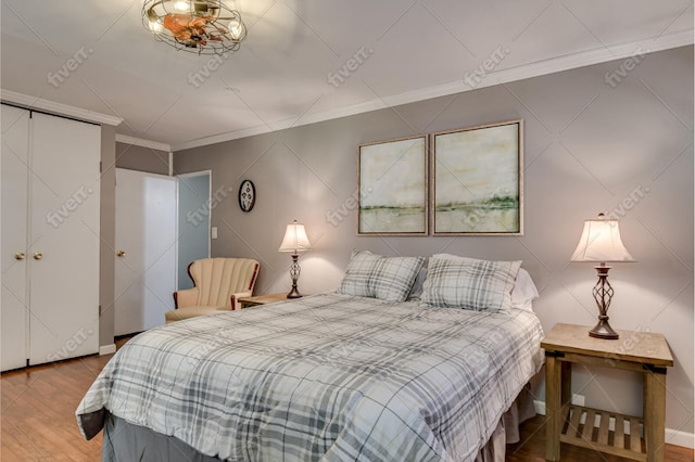 bedroom featuring ornamental molding and wood finished floors