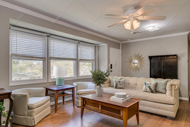 living room with a ceiling fan, visible vents, crown molding, and wood finished floors