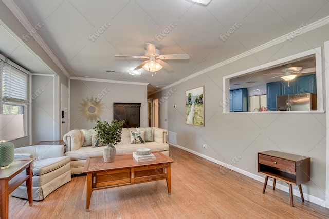 living area with baseboards, ceiling fan, and crown molding