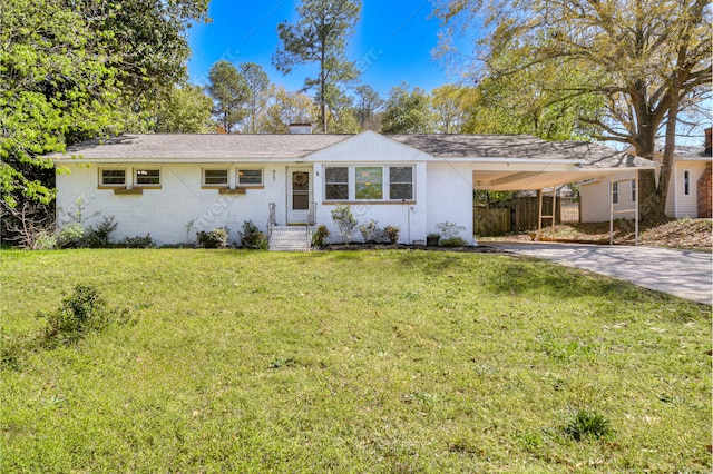 ranch-style house featuring an attached carport, brick siding, concrete driveway, and a front yard