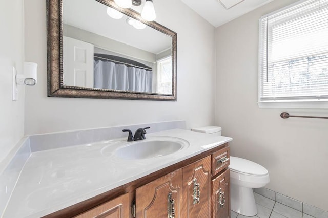 bathroom with tile patterned flooring, vanity, a wealth of natural light, and toilet