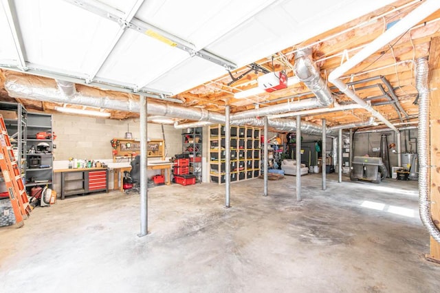 basement with gas water heater and a workshop area