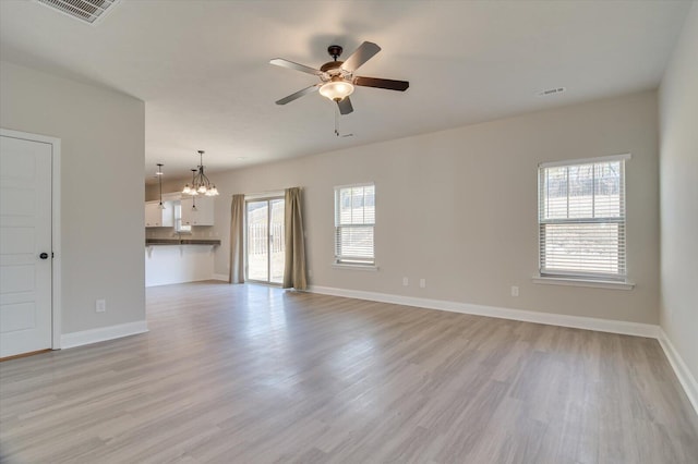 610 Turtle Crk Ln, Harlem, GA 30814 - unfurnished living room with light wood-type flooring, a chandelier, a ceiling fan, and baseboards