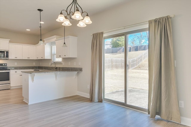 610 Turtle Crk Ln, Harlem, GA 30814 - kitchen featuring appliances with stainless steel finishes, a sink, a breakfast bar area, light wood-style flooring, and recessed lighting