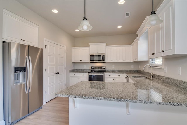 610 Turtle Crk Ln, Harlem, GA 30814 - kitchen featuring appliances with stainless steel finishes, a sink, a peninsula, white cabinets, and light stone countertops