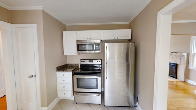 1443 Spring Hill Ter, Augusta, GA 30904 - kitchen with white cabinets, crown molding, dark stone countertops, stainless steel appliances, and baseboards