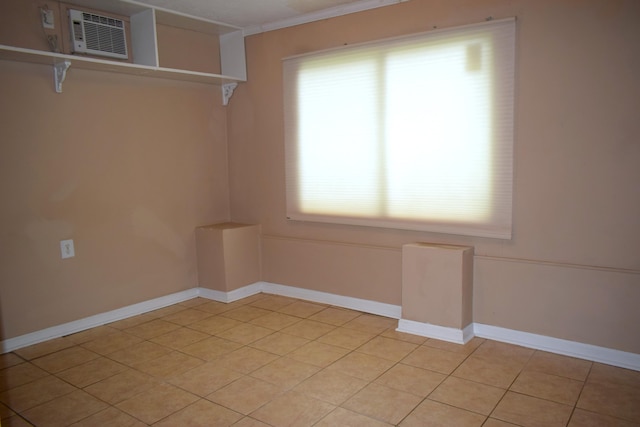 1443 Spring Hill Ter, Augusta, GA 30904 - spare room featuring crown molding, baseboards, light tile patterned flooring, and a wall mounted air conditioner