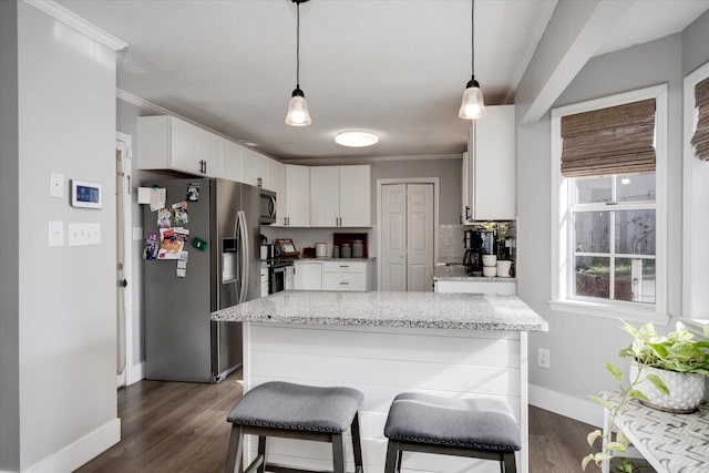 kitchen featuring white cabinetry, light stone countertops, pendant lighting, and stainless steel appliances