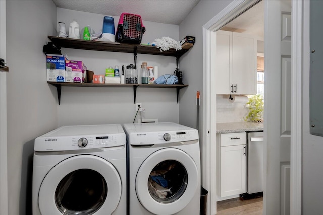 laundry room featuring separate washer and dryer, a textured ceiling, and light wood-type flooring