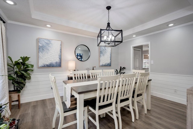 dining room featuring a chandelier, dark hardwood / wood-style flooring, ornamental molding, a raised ceiling, and a textured ceiling