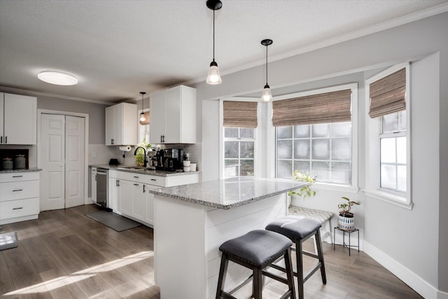 kitchen featuring white cabinetry, stainless steel dishwasher, and dark hardwood / wood-style floors