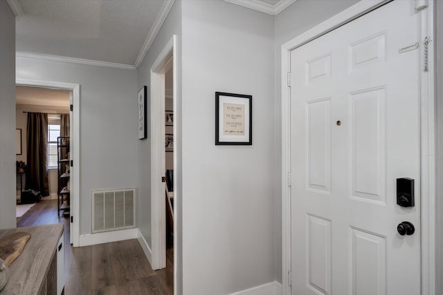 hallway with ornamental molding, dark wood-type flooring, and a textured ceiling