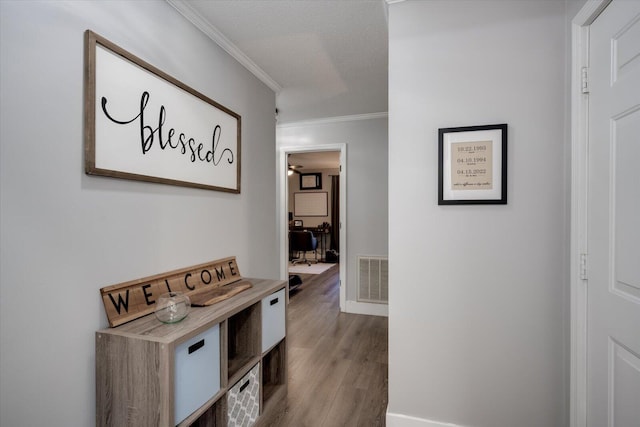 hall featuring crown molding, a textured ceiling, and light hardwood / wood-style flooring