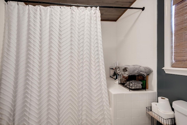 bathroom featuring a shower with curtain, wooden ceiling, and toilet