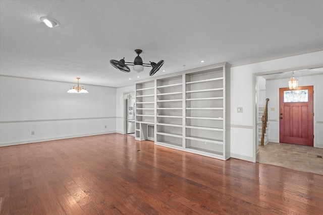 unfurnished living room featuring recessed lighting, baseboards, wood finished floors, and ceiling fan with notable chandelier