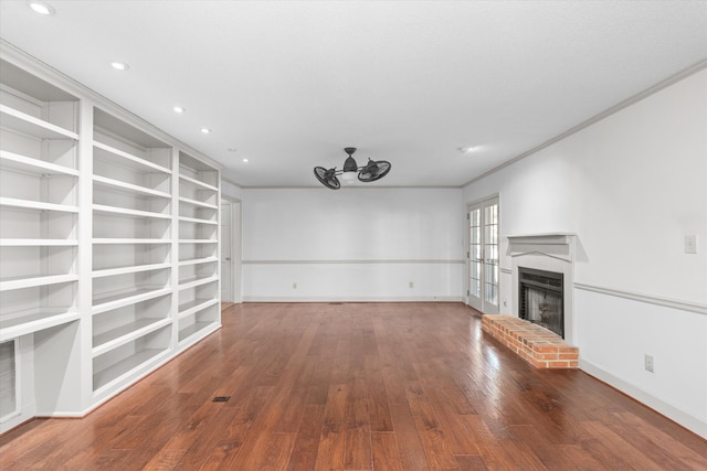 unfurnished living room featuring hardwood / wood-style flooring, a fireplace, baseboards, and recessed lighting