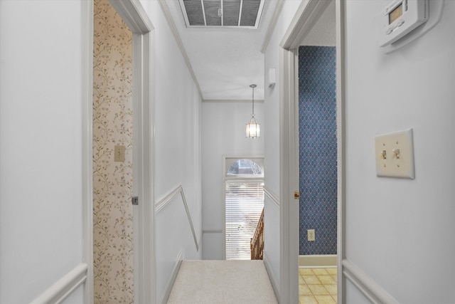 hallway with wallpapered walls, baseboards, and visible vents