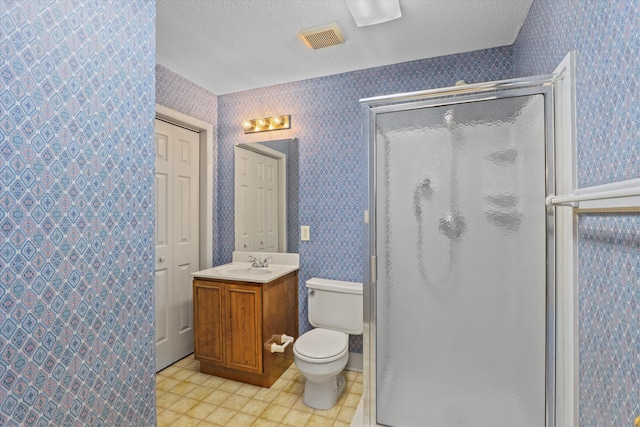 bathroom featuring a textured ceiling, a shower stall, visible vents, and wallpapered walls