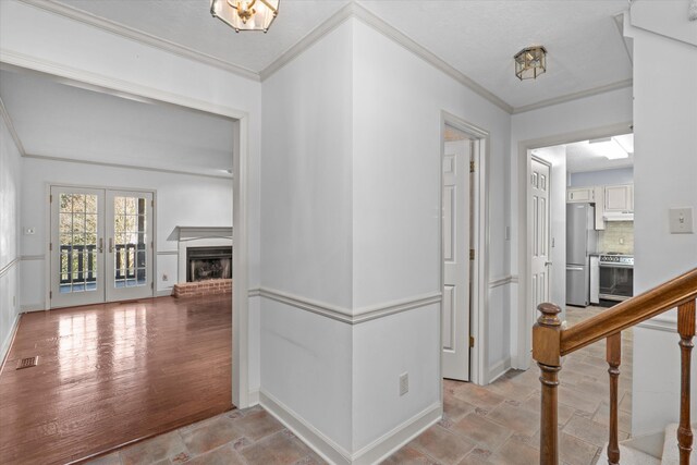 hallway featuring ornamental molding, french doors, visible vents, and baseboards