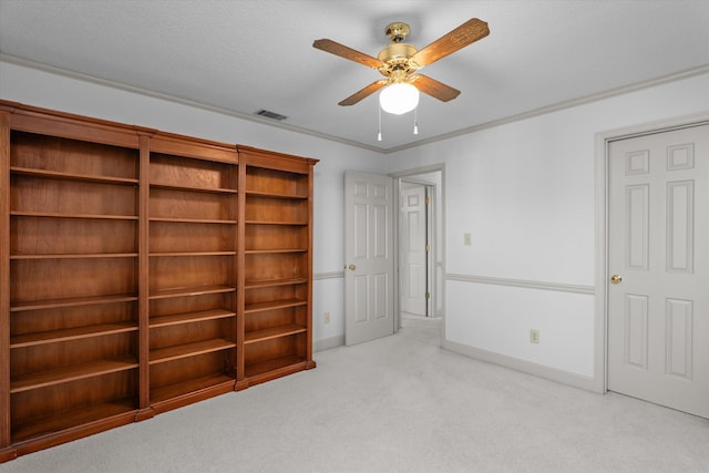 unfurnished bedroom featuring baseboards, ornamental molding, visible vents, and light colored carpet