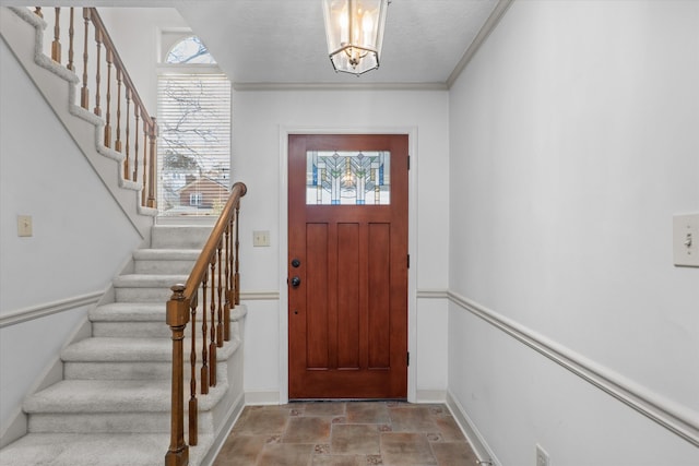 foyer with stone finish flooring, plenty of natural light, baseboards, and stairs