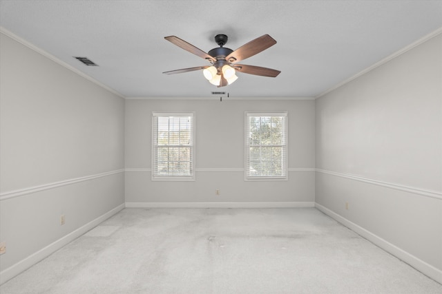 unfurnished room with light colored carpet, visible vents, crown molding, and baseboards