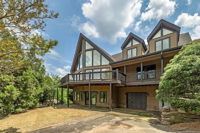 rear view of house with a wooden deck and a garage