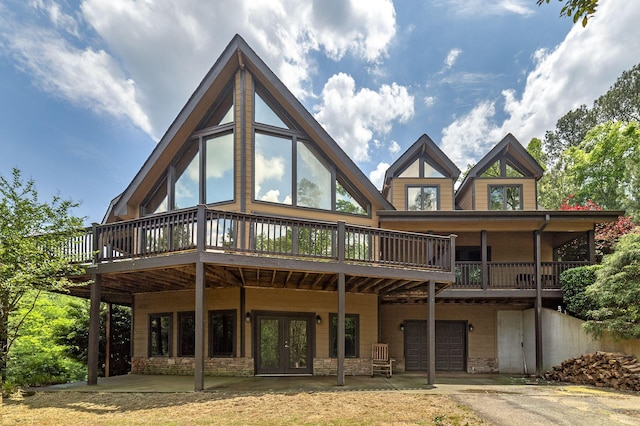 back of house with french doors, a garage, and a wooden deck