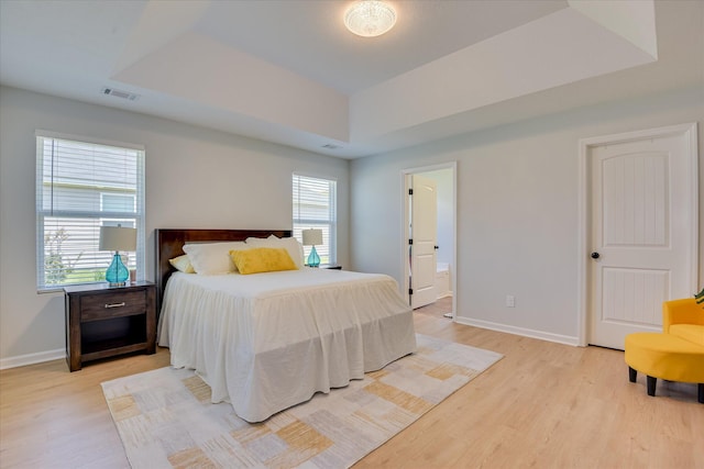2613 Inverness Dr, Hephzibah, GA 30815 - bedroom with light wood-type flooring, a tray ceiling, and ensuite bath